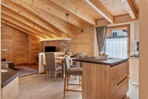 a kitchen and dining room with a table and chairs at Luxury Apartment Majon de Rita in Vigo di Fassa