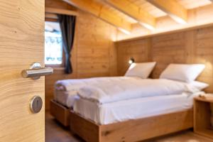 a bedroom with a bed in a wooden room at Luxury Apartment Majon de Rita in Vigo di Fassa