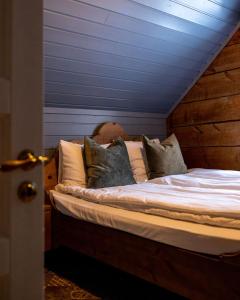 a bed with pillows on it in a room at Vollsnes Gjestehus in Stryn
