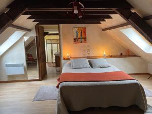 - une chambre mansardée avec un grand lit dans l'établissement Chambres Du Marais, à Tilques