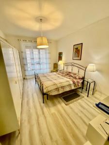 1 dormitorio con cama, escritorio y ventana en Appartamento Lella zona Terme Centro e vicino Villa Igea sito in Via Emilia 29, en Acqui Terme