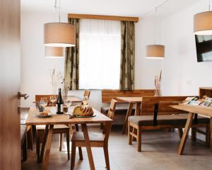 uma sala de jantar com mesas e cadeiras de madeira em Ferienhof Leopold in der Grub em Ort
