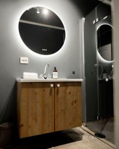 een badkamer met een wastafel en een douche met een spiegel bij Vollsnes Gjestehus in Stryn