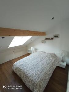 a white bedroom with a bed and a window at Meublé 3* neuf entre lacs, montagnes et bauges. in Mûres-les Balmettes