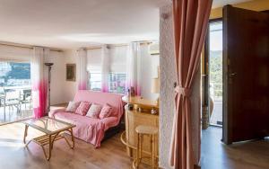 a living room with a pink couch and a table at Xalupa Salions Vistas in Tossa de Mar