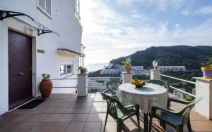 uma varanda com uma mesa e cadeiras e uma vista em Xalupa Salions Vistas em Tossa de Mar