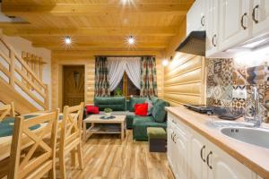 eine Küche und ein Wohnzimmer in einem Blockhaus in der Unterkunft DW KINGA & DOMKI na Granicznej z jacuzzi in Kacwin
