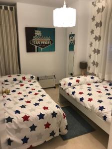 a bedroom with a bed covered in american stars at Coqueto apartamento a un tiro de piedra de la playa del Portil in El Portil