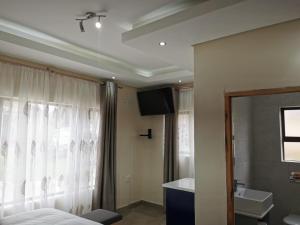 KwaNomzi Botique Lodge في Lusikisiki: غرفة نوم بسرير ومغسلة ونافذة