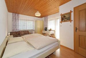 a bedroom with a large bed with a wooden ceiling at Pension Wiesengrund in Neuschönau