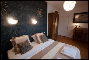 1 dormitorio con cama y pared en LOGIS HOTEL BELLEVUE RESTAURANT LA POMME d'OR, en Coucy-le-Château-Auffrique