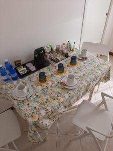 une table avec un tissu de table à fleurs, des tasses et des soucoupes dans l'établissement Casa di Clara, à Portogruaro