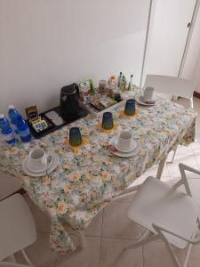 a table with a floral table cloth with cups and saucers at Casa di Clara in Portogruaro +37 photos