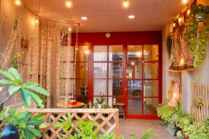 una habitación con una puerta roja y algunas plantas en 好窩旅店 en Hengchun Old Town