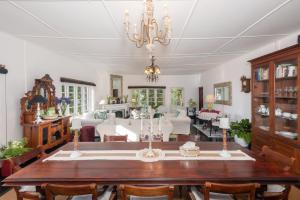 a dining room with a table and a living room at Highgrove Estate in Labugolla