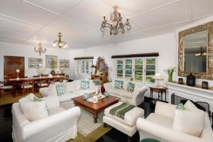 uma sala de estar com mobiliário branco e uma lareira em Highgrove Estate em Labugolla
