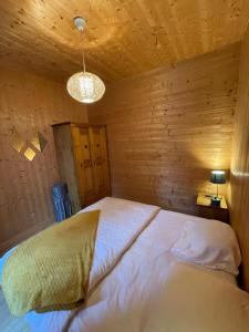 une chambre avec un lit dans une pièce en bois dans l'établissement Appt lumineux centre ville du Mont Dore Vue Sancy, à Le Mont-Dore