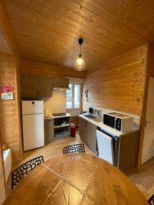 une cuisine avec une table et des chaises dans une pièce dans l'établissement Appt lumineux centre ville du Mont Dore Vue Sancy, à Le Mont-Dore 2 autres photos