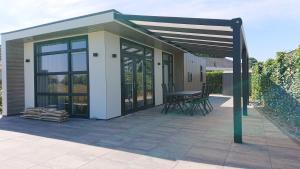 een paviljoen met een tafel en stoelen op een patio bij Cube IJsselzicht in Lathum