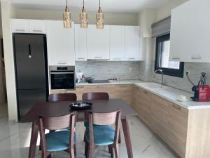 a kitchen with a table and chairs and a black refrigerator at Finix Loft Trikala in Tríkala