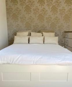 een bed met witte lakens en kussens in een slaapkamer bij ZIN AND ZEN SUPERBE vue SPA SAUNA&JACUZZI in Vitrolles