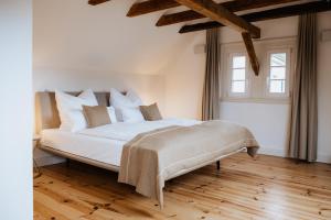 una camera da letto con un grande letto bianco con cuscini bianchi di Hotel Gut Landscheid a Burscheid