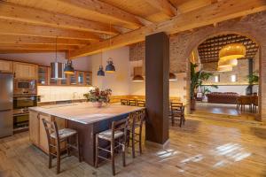 una cocina abierta con una isla grande en una cocina con techos de madera en Masos Can Sot, en Pont de Molins
