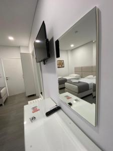 a room with a mirror and a bed and a couch at Edina in Sarandë