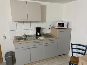 una piccola cucina con lavandino e forno a microonde di Ferienwohnung Weidner a Rehau
