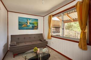 sala de estar con sofá y mesa de cristal en Ko'ëtï Yahveh, en Punta del Diablo