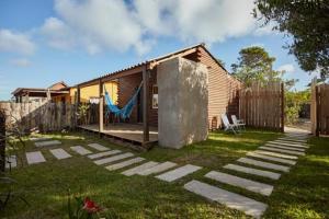 a house with a hammock in a yard at Ko'ëtï Yahveh in Punta Del Diablo