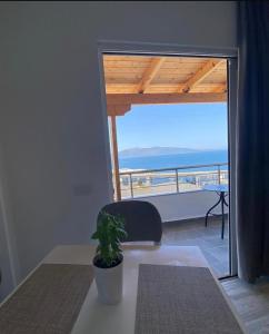 a room with a table and a chair and a view of the ocean at Edina in Sarandë