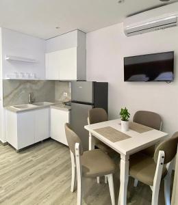 a kitchen with a table and chairs in a room at Edina in Sarandë