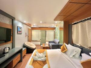 a bedroom with a large bed and a living room at THE MAGNUM in Deoghar