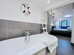 ein Badezimmer mit einer Badewanne und einem großen Spiegel in der Unterkunft Ferienwohnung Meeresblick Haus Granitz in Prora in Binz