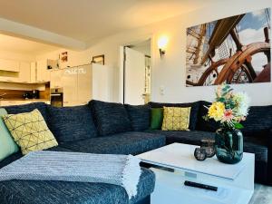 ein Wohnzimmer mit einem blauen Sofa und einem Tisch in der Unterkunft Ferienwohnung Meeresblick Haus Granitz in Prora in Binz
