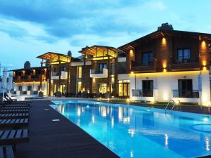 a hotel with a swimming pool in front of a building at Irene's Resort in Kato Loutraki