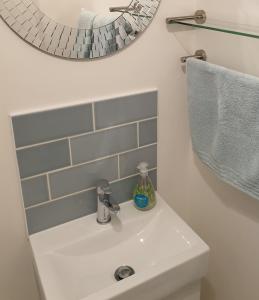 a white sink in a bathroom with a mirror at The Studio in Felpham