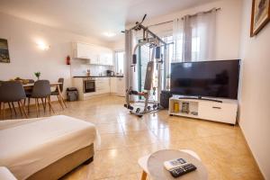 uma sala de estar com uma grande televisão e uma sala de estar com uma mesa em Nono Jure , private pool & sauna em Milna