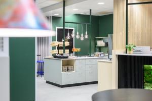 una cucina con pareti verdi e piano di lavoro bianco di GreenStar Hotel Oulu a Oulu