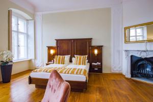 a bedroom with a large bed and a fireplace at Schlosshotel Fürstlich Drehna in Drehna