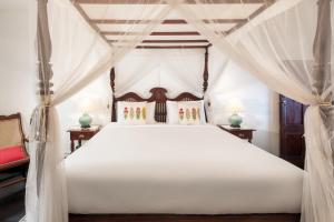 a bedroom with a white bed with a canopy at Highgrove Estate in Labugolla