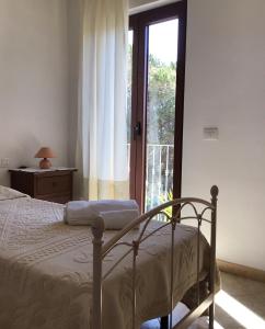 a bedroom with a bed and a sliding glass door at Agriturismo Lu Stabbiacciu in Aglientu