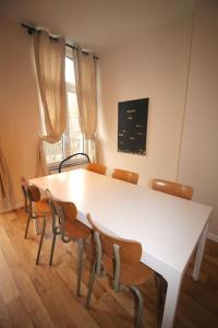 - une table et des chaises blanches dans la chambre dans l'établissement Appartement 3 chambres en plein centre ville, à Liège