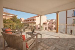 a patio with a table and chairs on a balcony at Hotel Muita di Mari in Santa Teresa Gallura