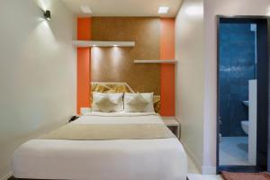 a bedroom with a bed with an orange wall at Mannars Deluxe Lodge in Mysore
