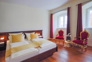 sypialnia z 2 łóżkami i 2 krzesłami w obiekcie Schlosshotel Fürstlich Drehna w mieście Drehna
