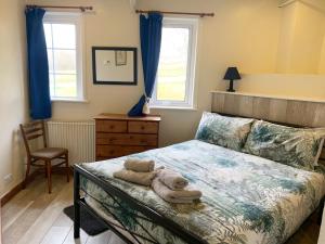 - une chambre avec un lit et des serviettes dans l'établissement Brookside, à Ellingham