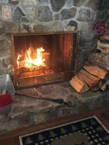 a brick fireplace with a fire in it at APPLEJAX cabin steps from a u pick orchard in Sandisfield