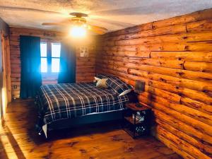 Un dormitorio con una pared de madera y una cama. en APPLEJAX cabin steps from a u pick orchard en Sandisfield